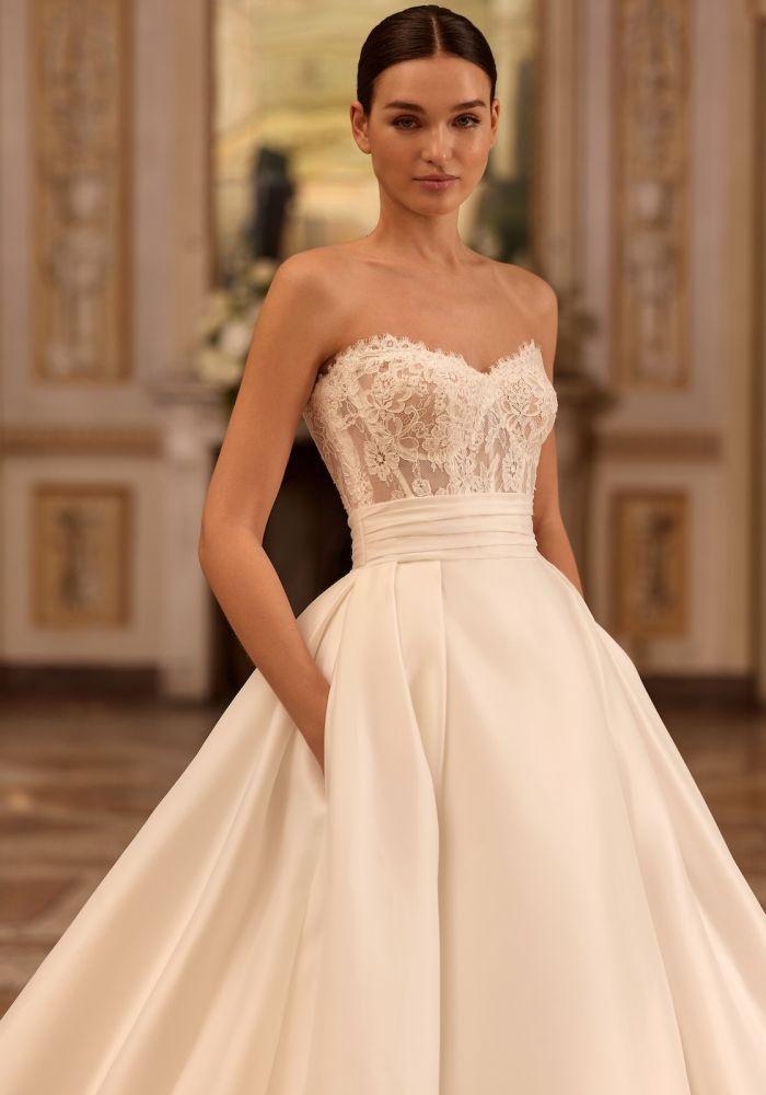 Robe de mariée ARTEMISIA de  – Matière : dentelle – dentelle, satin, organza, boléro amovible dentelle, col montant manches longues, traîne amovible, cérémonie religieuse