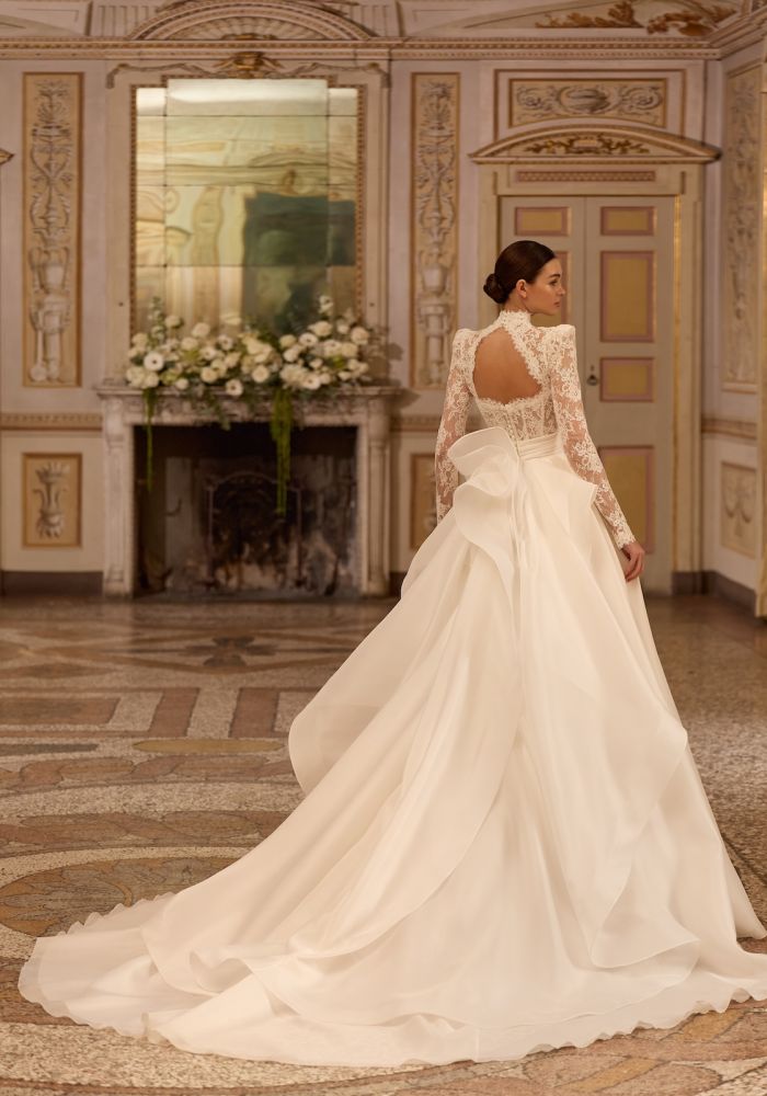 Robe de mariée ARTEMISIA de  – Matière : dentelle – dentelle, satin, organza, boléro amovible dentelle, col montant manches longues, traîne amovible, cérémonie religieuse