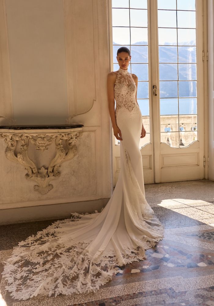 Robe de mariée ONYX de ALBERTO PALATCHI – Matière : crepe – fourreau, crêpe, bustier dentelle, col altier montant, dos nu, boutons couture, traîne appliqués dentelle