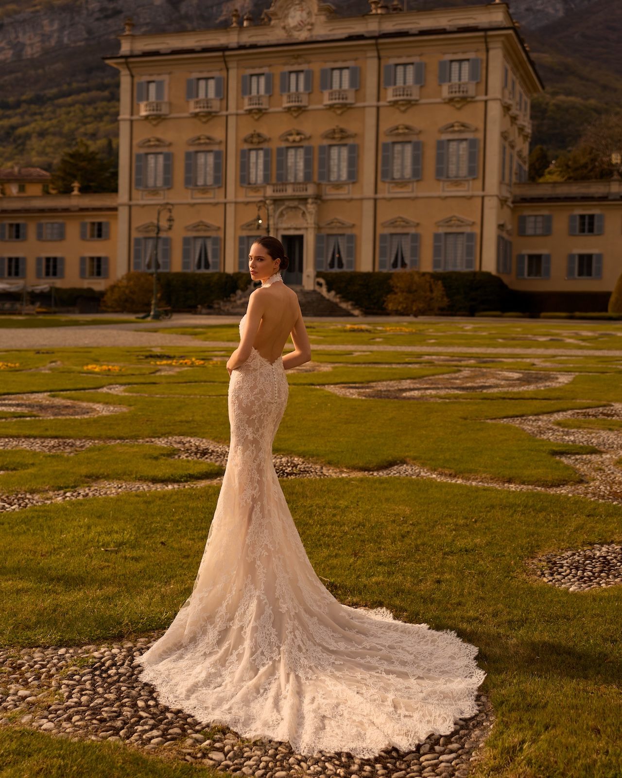 Robe de Mariée TOPAZ de ALBERTO PALATCHI – Matière : dentelle – dentelle, fourreau, col halter dentelle, dos entièrement nu, boutons couture, traîne dentelle
